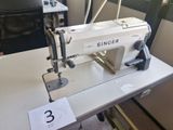 a white sewing machine sitting on a table in a room