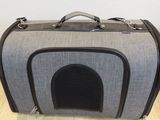 a gray and black bag sitting on a wooden floor