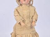 a small doll that is standing on a white surface