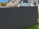 a black privacy fence in front of a house