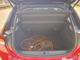 the trunk of a red car with an orange cord in the trunk