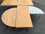 deux tables et une table installée sur un parking devant un immeuble