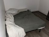 un lit situé dans une petite chambre avec du parquet