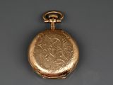 une montre de poche en or posée sur une table