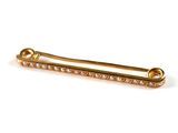 un gros plan d'une broche en or sertie de diamants sur fond blanc