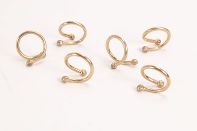six pairs of gold - plated ear rings on a white surface