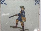 a picture of a man with a gun on a tile