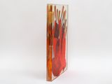 a glass vase with a bunch of paint brushes inside of it