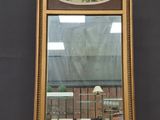 une image représentant un miroir posé sur un pied, sur lequel est accroché un tableau