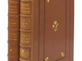 un vieux livre marron aux tranches dorées, orné d'une fleur dorée sur la couverture