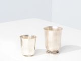 a pair of silver cups on a white surface