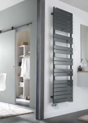 une photo d'une salle de bains avec un grand miroir et un radiateur
