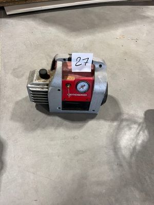an image of a small air compressor sitting on the floor