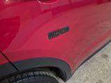 a close up of a red car with a sticker on it