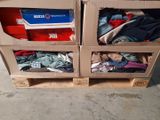 two boxes that have clothes in them on a pallet