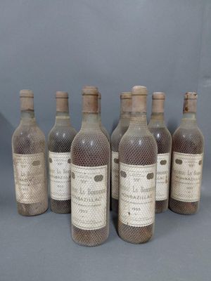 six bouteilles de vin sont alignées sur une surface grise