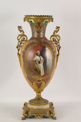 a gold vase with a picture of a woman on it