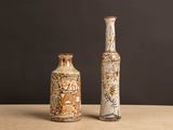deux vases posés sur une table, sur fond noir