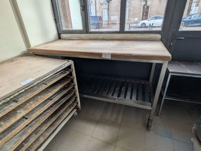 une pile de plateaux en bois posée sur une table devant une fenêtre