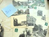de nombreuses cartes postales anciennes posées sur un bureau, à côté d'un clavier et d'une souris