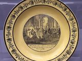 une vieille assiette sur laquelle est représenté un homme et une femme