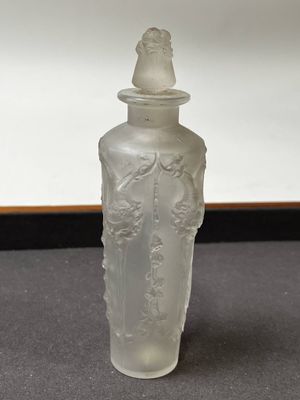 une bouteille en verre transparent avec un bouchon, posée sur une table