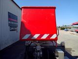 a red dump truck parked in front of a building