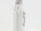 a bottle of coca cola sitting on a white surface