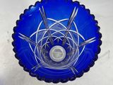 a blue glass bowl with a candle inside of it
