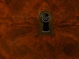 a close up of a wooden table with a keyhole in it