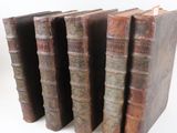 plusieurs vieux livres empilés sur une surface blanche