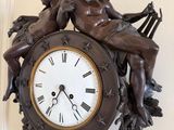 a clock that has a statue of a man and a woman on it