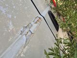 a white van that has a rusted door handle on the side of it