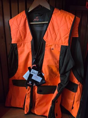 an orange vest is hanging on a wooden wall in a room