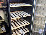 many shelves of wine bottles in a cooler in a store