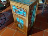 a wooden cabinet with a drawer on top of a tile floor