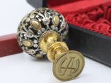 a small red box with a gold seal and a red pen
