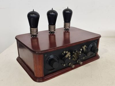 une boîte en bois surmontée de trois boutons noirs