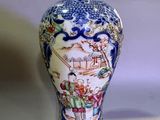 a blue and white vase with a picture of people on it