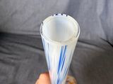 a person holding a glass with a blue and white design on it