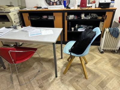a desk with a backpack on it and a chair in front of it