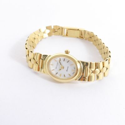 une photo d'une montre-bracelet pour femme montée sur un bracelet en or