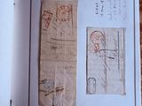 un livre ouvert sur lequel sont collés plusieurs timbres