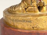 a gold statue of a man with a dog on his feet
