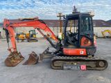 une petite excavatrice garée sur un parking