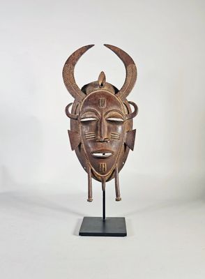 Masque dit Kpelie en tôle de laiton patiné.