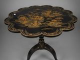 a black and gold table with a flower design on it