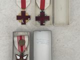 three medals and a card in a box on a white surface