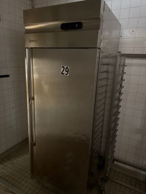 un congélateur en acier inoxydable dans un coin de la salle de bains