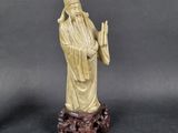 an image of a statue of a monk holding a staff